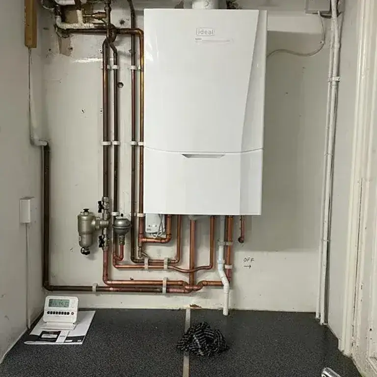 A tankless water heater sitting next to a wall.