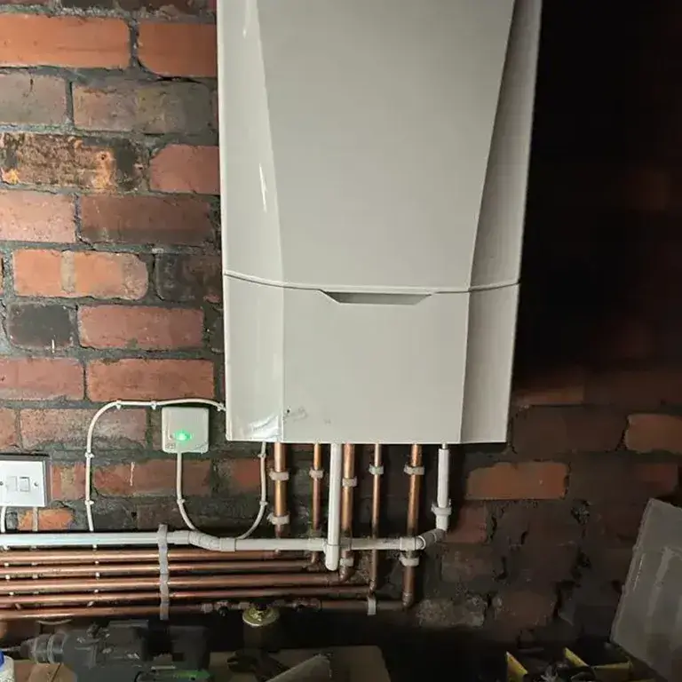 there is a tank type water heater on a brick wall