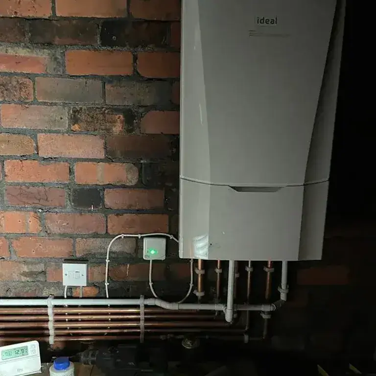 there is a tankless water heater on the wall next to a brick wall