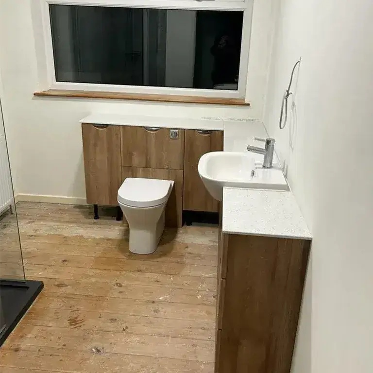 there is a bathroom with a toilet, sink, and shower in it