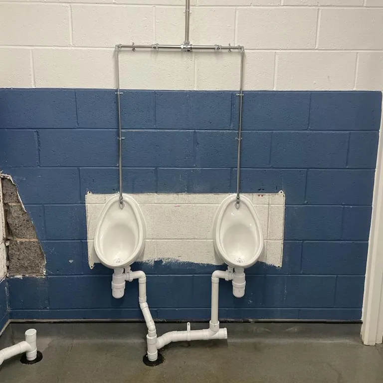 two urinals mounted to a wall in a bathroom