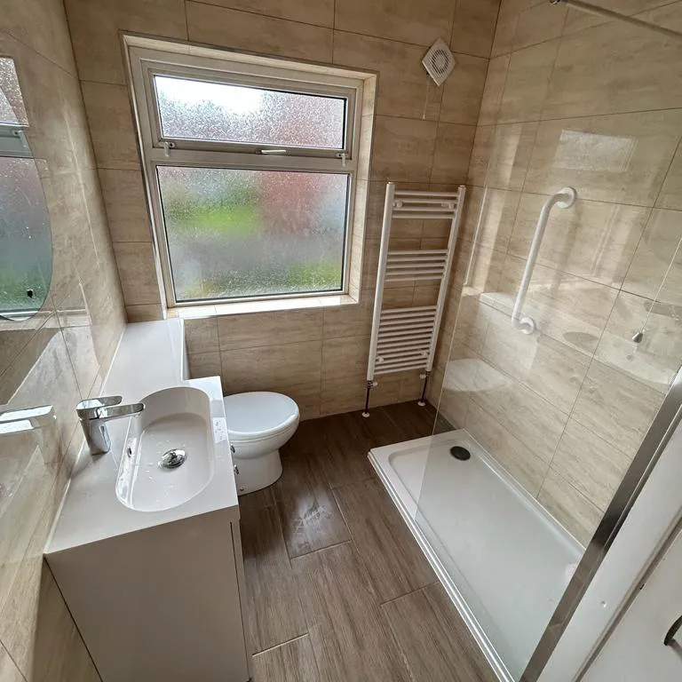 a bathroom with a toilet, sink, and shower