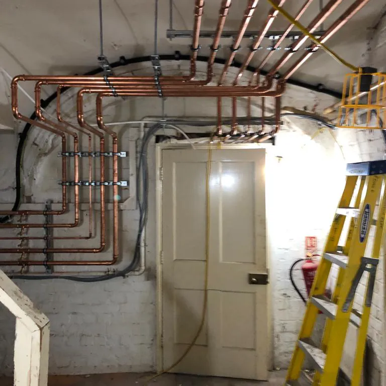 a room with a ladder and some pipes on the wall