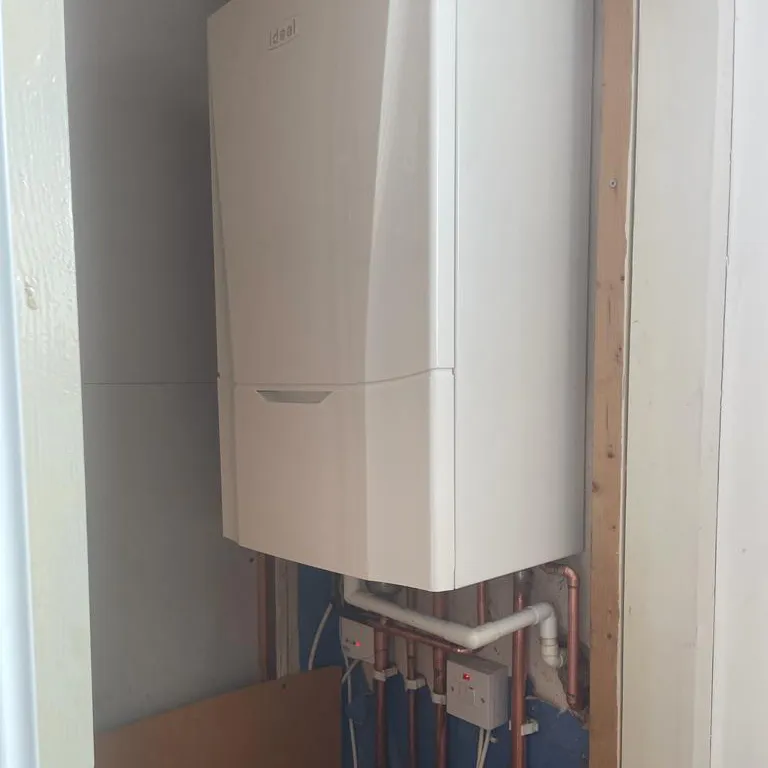 a white tank mounted to the side of a wall